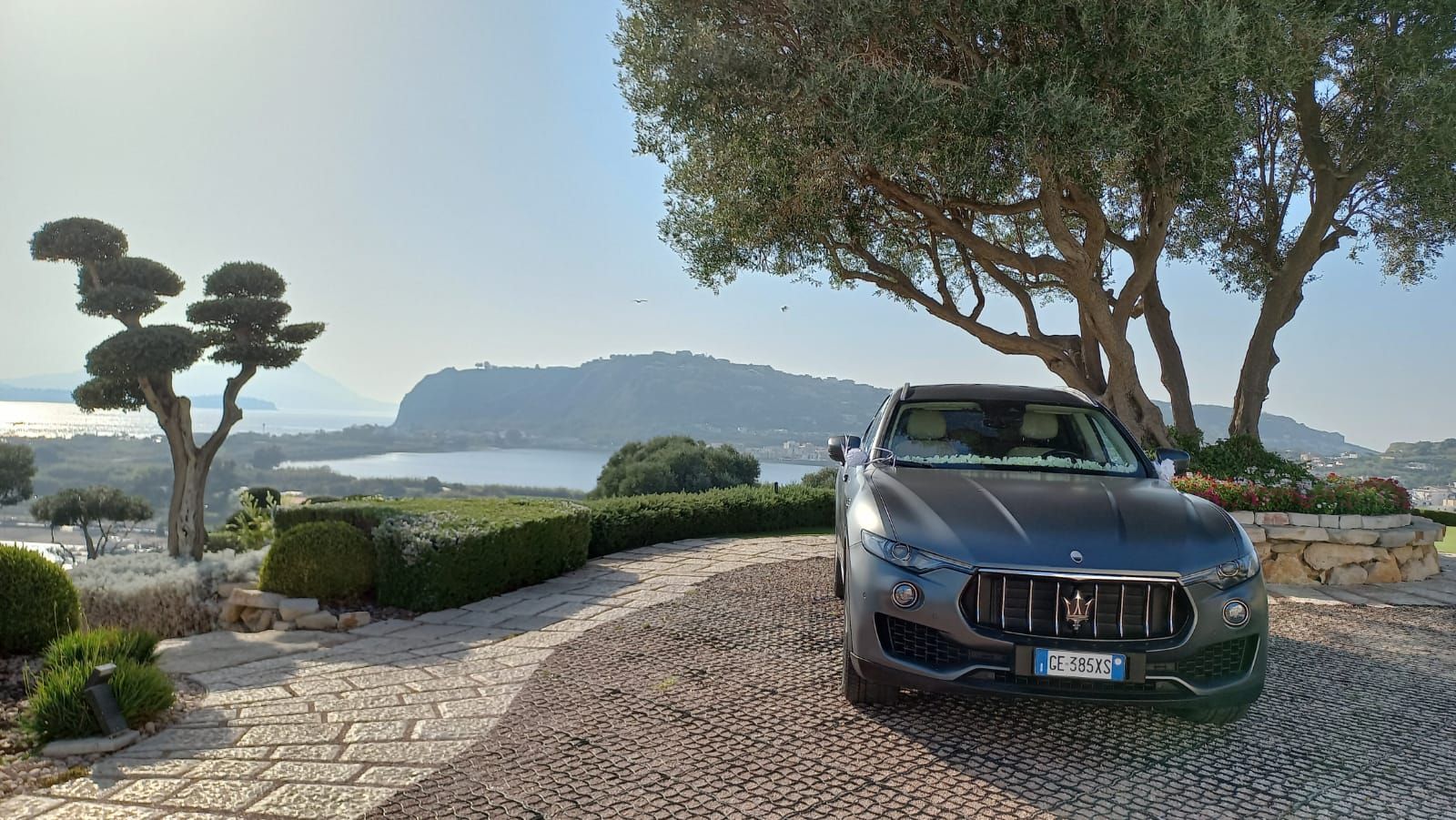Maserati grigia opaca parcheggiata davanti al mare per un evento