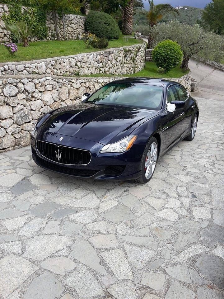 Maserati Quattroporte blu su un viale di pietra